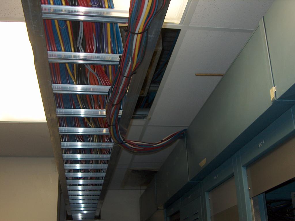 The temporary wires run overhead across the racks and upto a cable duct.